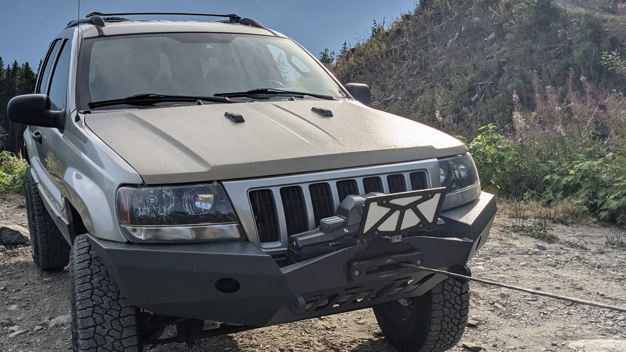 The Cascadia 4x4 Flipster V3 winch license plate mounting system on the front of a Jeep Grand Cherokee WJ